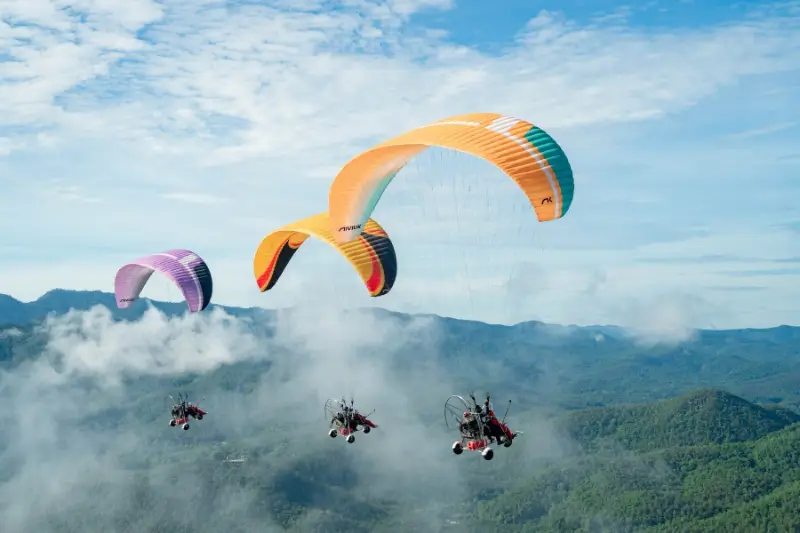 Several paramotors flying together over Chiang Mai
