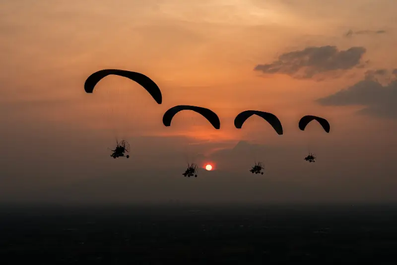 Paramotor wings flying at sunset